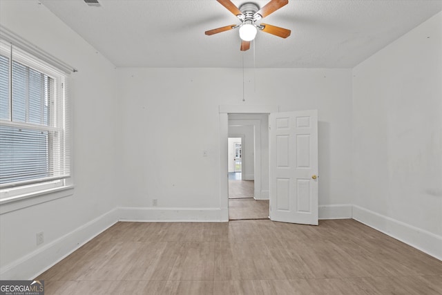 unfurnished room with ceiling fan and a textured ceiling