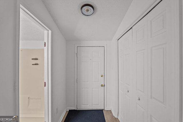 hall with hardwood / wood-style floors and a textured ceiling