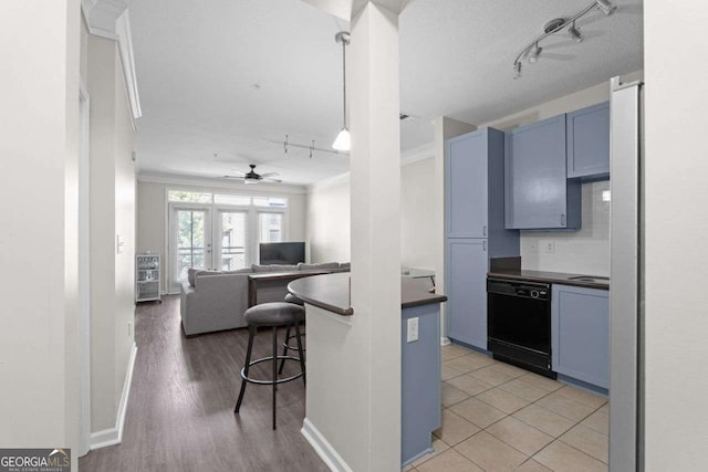 kitchen featuring a kitchen breakfast bar, hanging light fixtures, light wood-type flooring, blue cabinetry, and black dishwasher