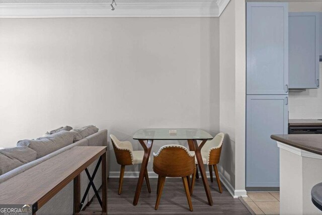 dining room with crown molding and light wood-type flooring