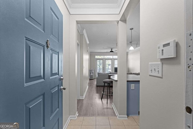 hall with crown molding, french doors, and light hardwood / wood-style floors