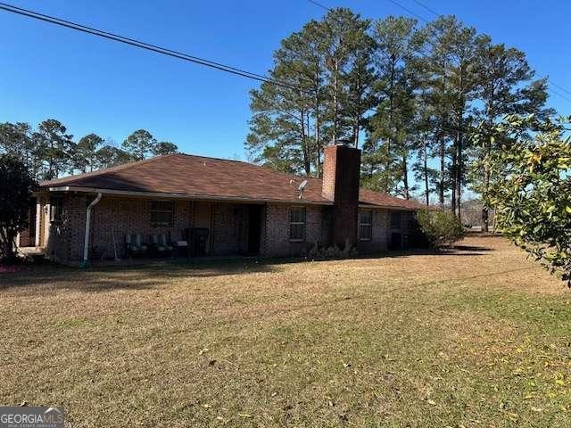 rear view of house featuring a lawn