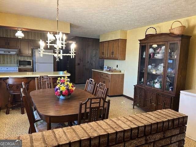 dining room featuring a textured ceiling and a notable chandelier