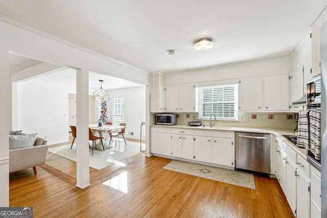 kitchen with white cabinets, appliances with stainless steel finishes, and tasteful backsplash