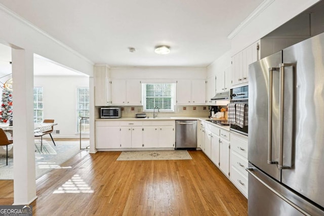 kitchen featuring backsplash, stainless steel appliances, sink, light hardwood / wood-style floors, and white cabinetry