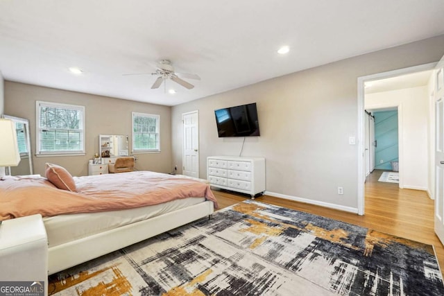 bedroom with a closet, hardwood / wood-style flooring, and ceiling fan