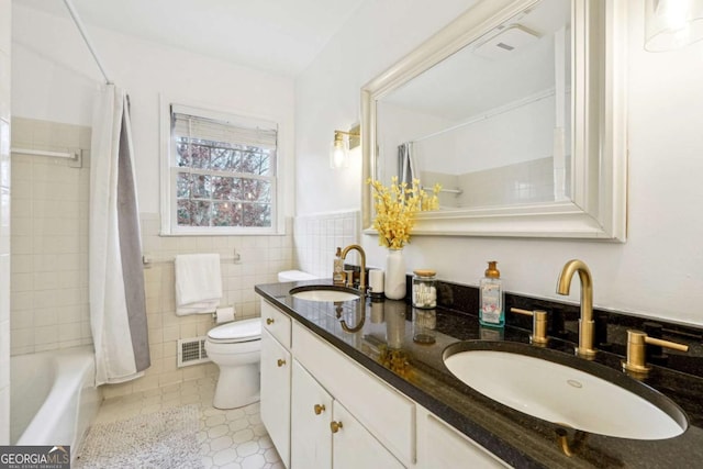 full bathroom with vanity, tile patterned floors, toilet, shower / bath combo with shower curtain, and tile walls