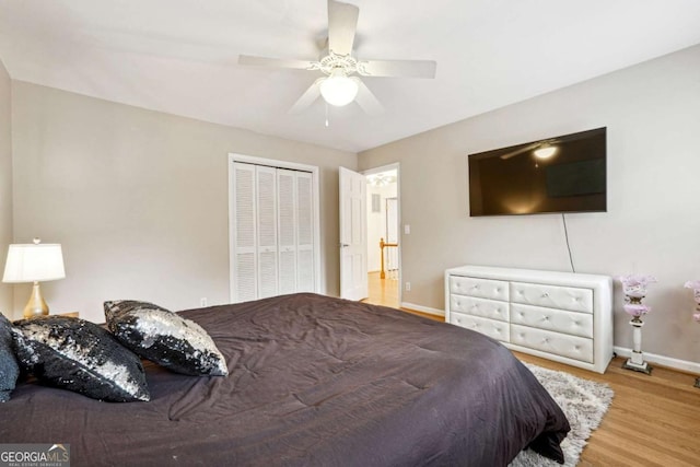 bedroom with hardwood / wood-style floors, a closet, and ceiling fan