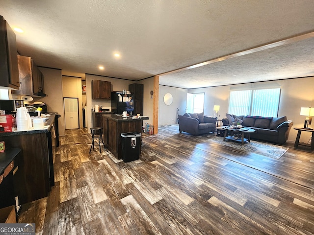 living room featuring dark wood-type flooring and a textured ceiling