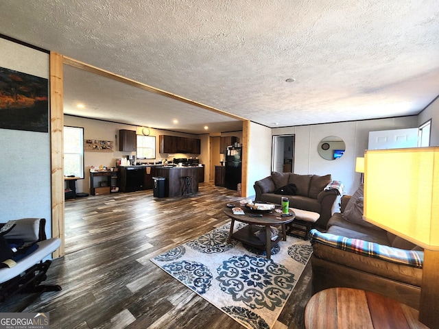 living room with dark wood-type flooring and a textured ceiling