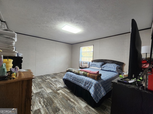 bedroom with hardwood / wood-style flooring and a textured ceiling