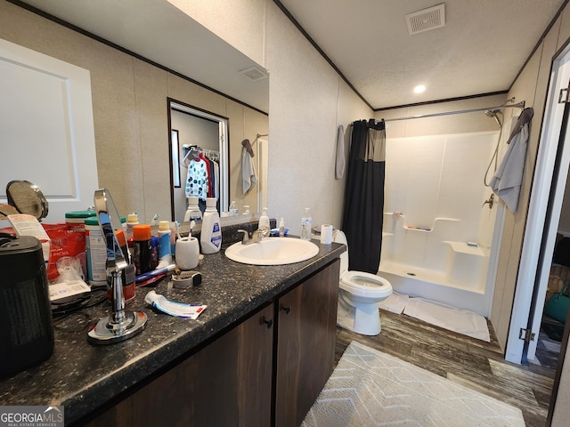 bathroom with hardwood / wood-style flooring, vanity, curtained shower, and toilet