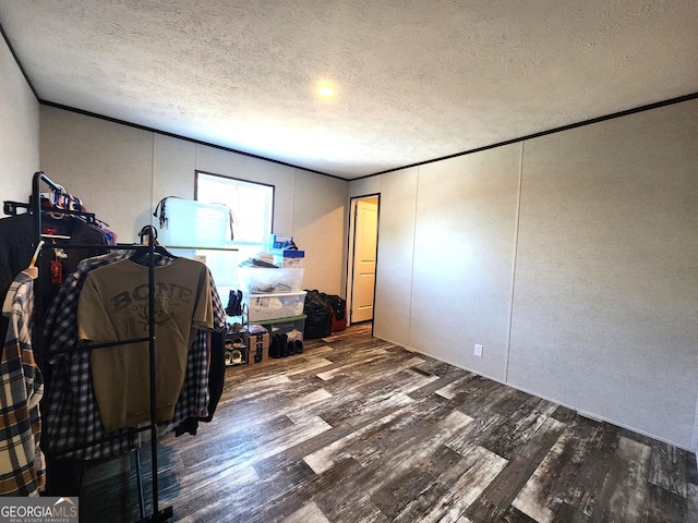 interior space featuring a textured ceiling and dark wood-type flooring