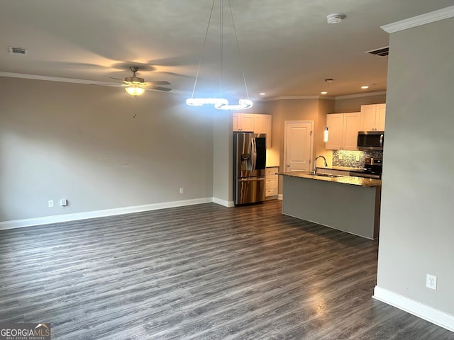 unfurnished living room featuring ceiling fan, sink, dark wood-type flooring, and ornamental molding