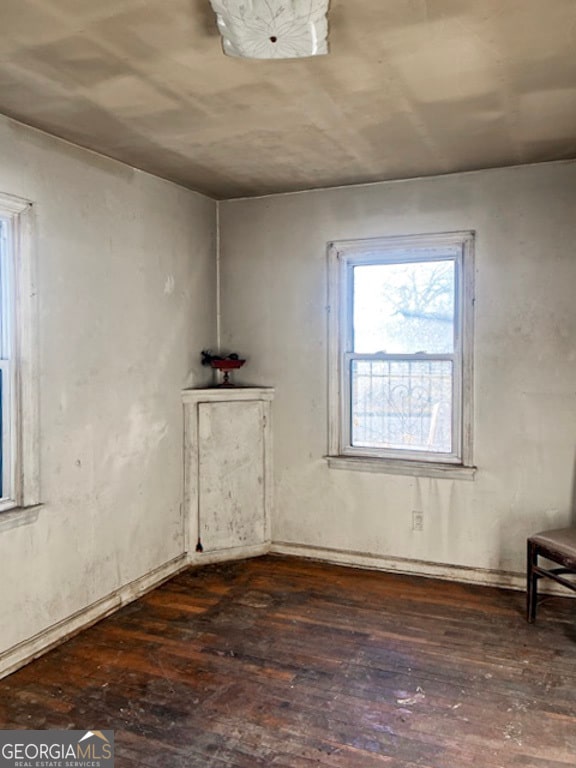 unfurnished room with dark hardwood / wood-style flooring