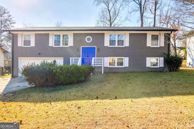 raised ranch with a front yard and a garage