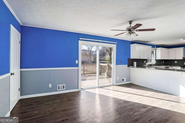 interior space with ceiling fan, wood-type flooring, and a textured ceiling