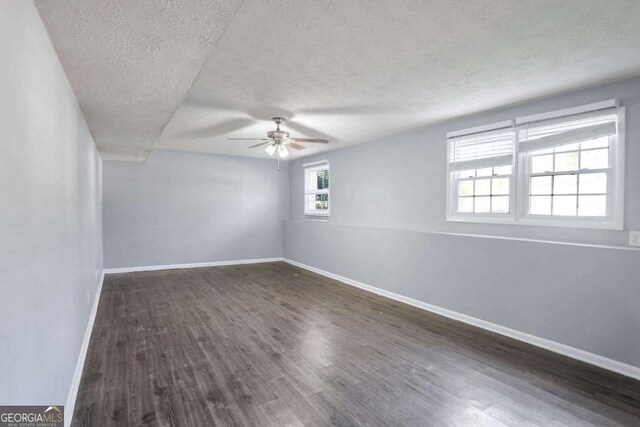 unfurnished room featuring a textured ceiling, ceiling fan, and dark wood-type flooring