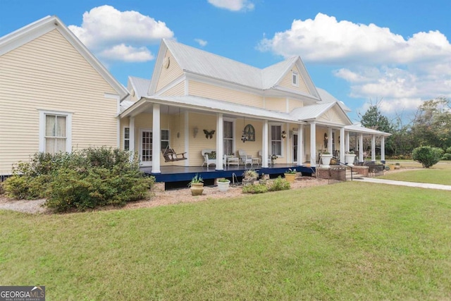 rear view of property with a lawn and covered porch