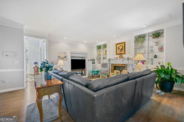 living room featuring hardwood / wood-style floors, built in features, and ornamental molding