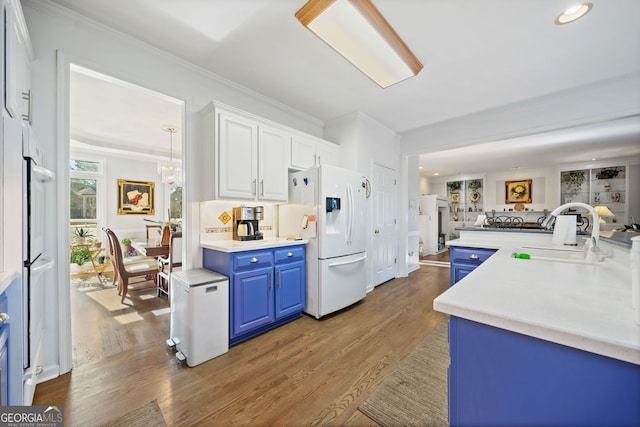 kitchen featuring white cabinetry, sink, dark hardwood / wood-style flooring, white refrigerator with ice dispenser, and blue cabinets