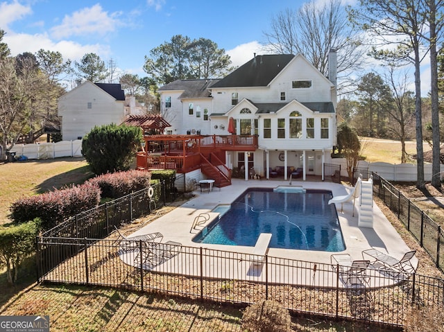 rear view of property with a swimming pool side deck and a patio area