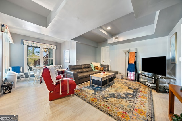 living room featuring a notable chandelier and light wood-type flooring