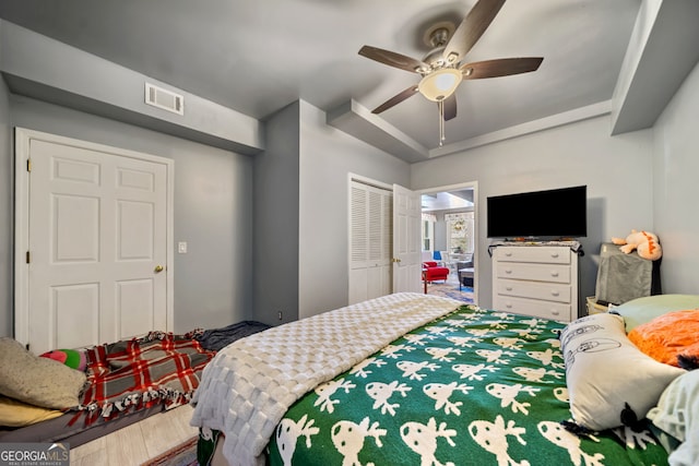 bedroom with hardwood / wood-style flooring, ceiling fan, and a closet