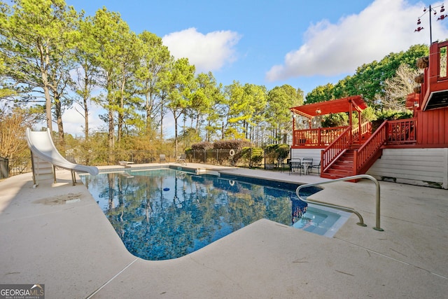 view of swimming pool with a patio, a diving board, and a water slide