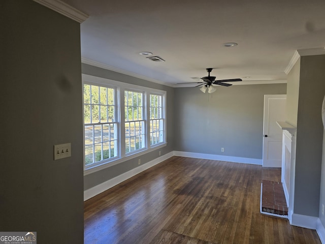 empty room featuring crown molding, ceiling fan, dark hardwood / wood-style floors, and a brick fireplace