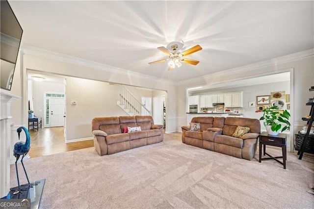 carpeted living room with ceiling fan and ornamental molding