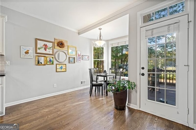 doorway to outside with crown molding and dark hardwood / wood-style floors