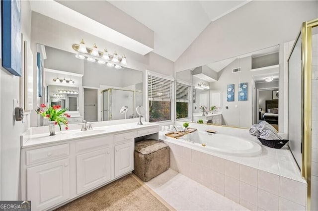 bathroom with vanity, separate shower and tub, and vaulted ceiling