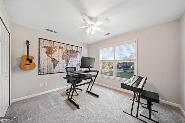 carpeted home office featuring ceiling fan