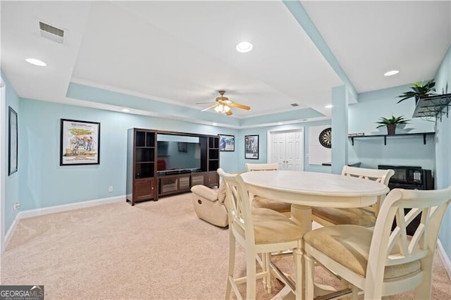 carpeted dining area featuring ceiling fan and a tray ceiling