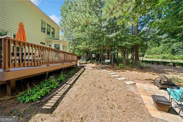 view of yard with a deck and an outdoor fire pit