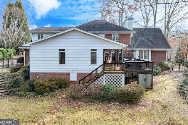 back of property featuring a lawn and a wooden deck