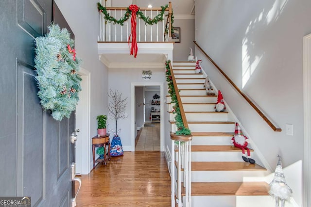 foyer with crown molding and hardwood / wood-style floors