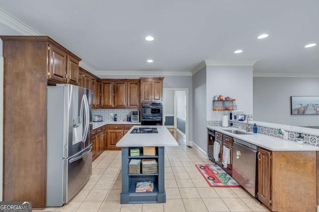 kitchen featuring black appliances, a kitchen island, ornamental molding, and sink