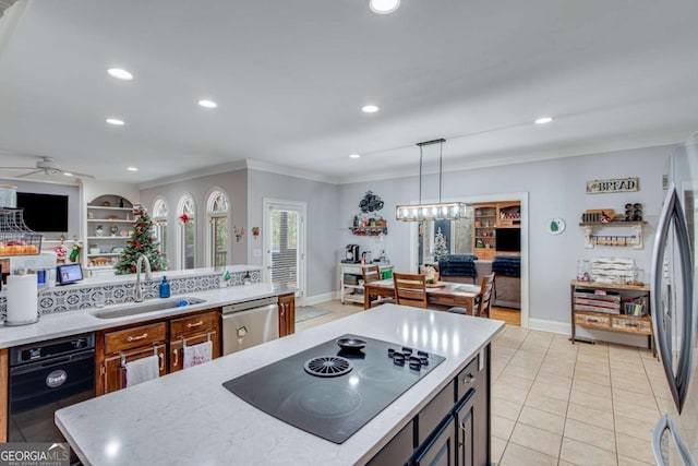 kitchen with appliances with stainless steel finishes, ceiling fan with notable chandelier, sink, light tile patterned floors, and hanging light fixtures