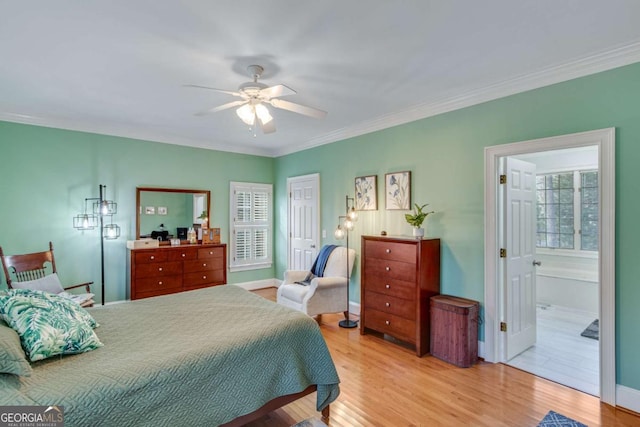 bedroom featuring connected bathroom, light hardwood / wood-style flooring, ceiling fan, and crown molding