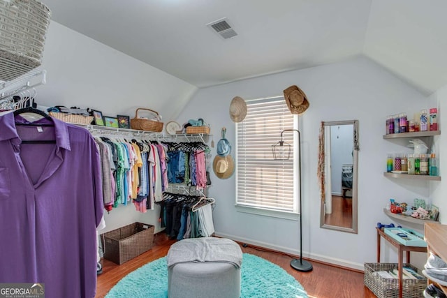 walk in closet with hardwood / wood-style floors and lofted ceiling