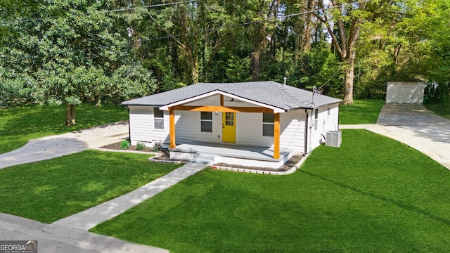 bungalow-style home with an outdoor structure, a front yard, cooling unit, covered porch, and a garage