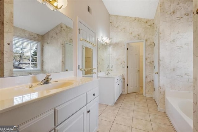 bathroom with vanity, tile patterned floors, and a bathtub