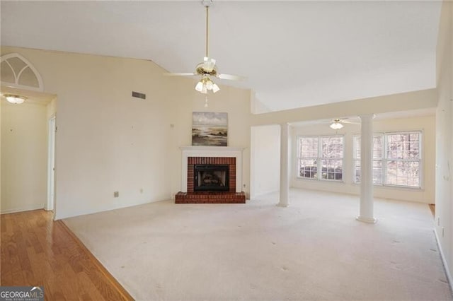 unfurnished living room with a brick fireplace, ceiling fan, and lofted ceiling