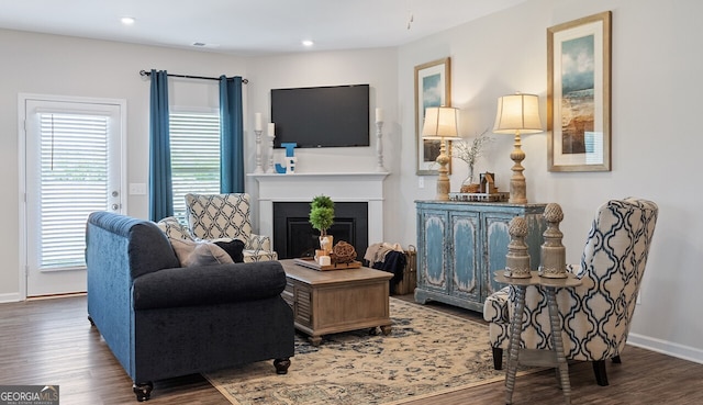 living room with recessed lighting, a fireplace, wood finished floors, and baseboards