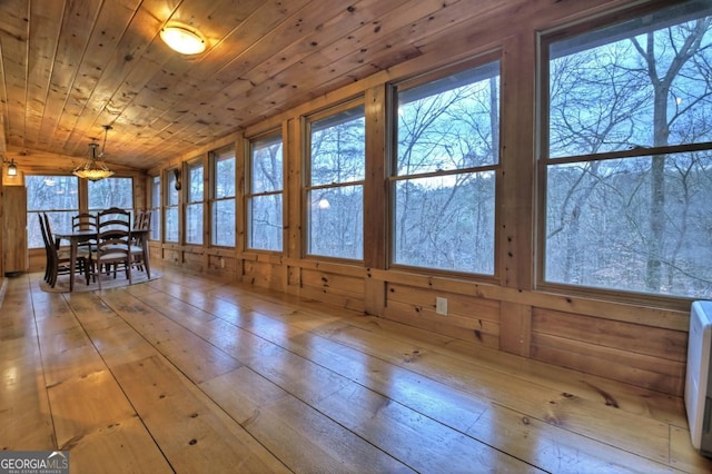 unfurnished dining area featuring hardwood / wood-style floors, wooden ceiling, and vaulted ceiling