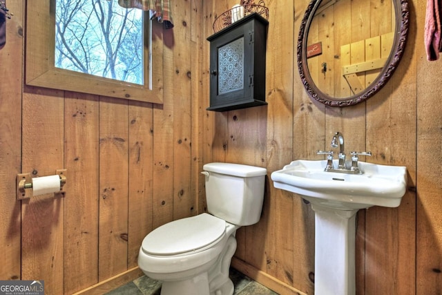 bathroom featuring toilet and wooden walls