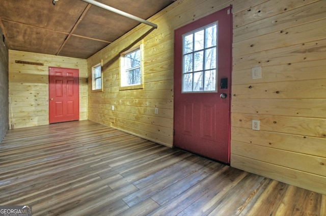 entryway with wood-type flooring, wooden ceiling, and wooden walls