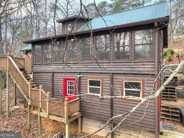 rear view of property featuring a sunroom